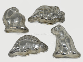 Four vintage dinosaur-shaped baking tins