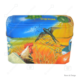 Orange mit blauer Blechdose von Wasa für Knäckerbröd mit einem Bild von Hahn, Biene, Sonnenblume, Getreide und Früchten