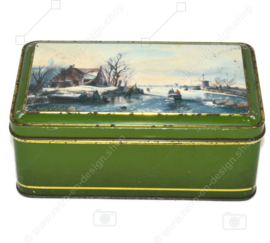 Green vintage biscuit tin with a Dutch scene in a winter landscape
