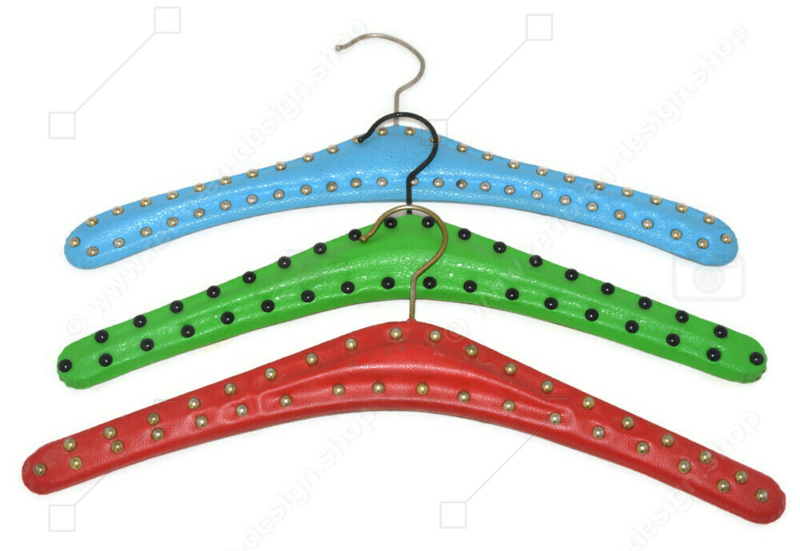 Set van drie vintage Skai kledinghangers in lichtblauw, lichtgroen en rood met metalen studs