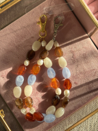 Handmade Telefoon sieraad / hanger grote  kralen in bruin-lichtblauw combi. Met parels. Zilver.