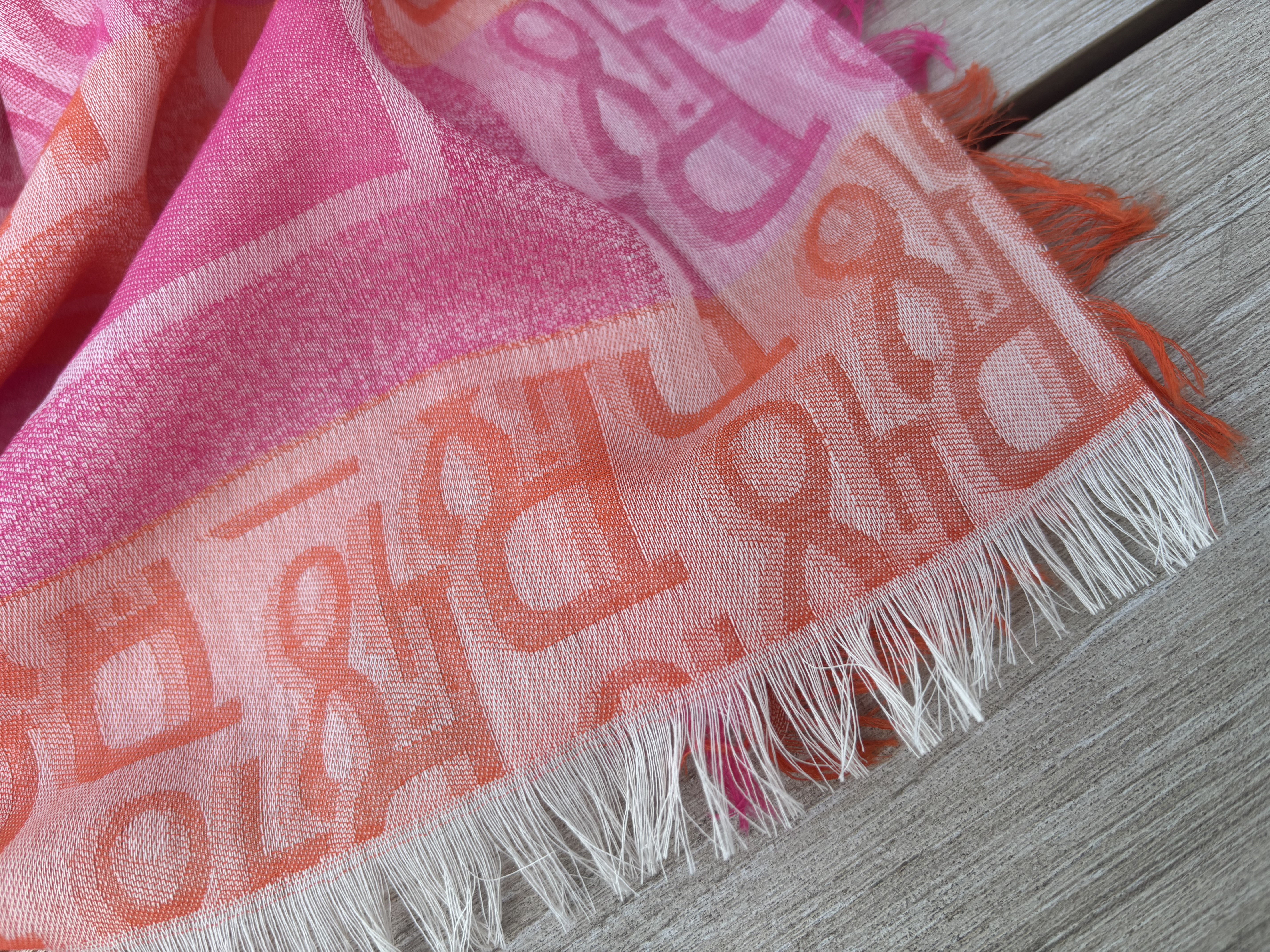 Luchtige dunne sjaal, vierkant. Roze - oranje met letters.