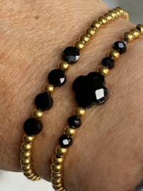 Elastieke Armband van stainless steel kralen en 4 zwarte glas kralen.