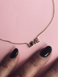 RVS (stainless steel) ketting. Tekst “love”. Goudkleurig met zwart.