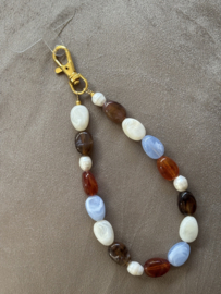 Handmade Telefoon sieraad / hanger grote  kralen in bruin-lichtblauw combi. Met parels. Goud.