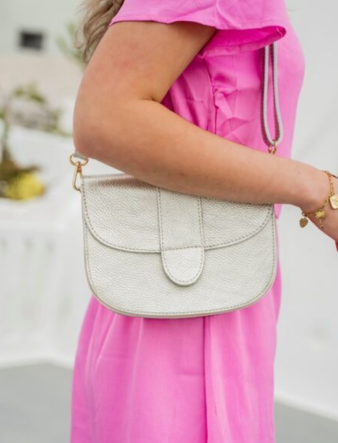 Leren tas met halfronde klep. Licht goud.