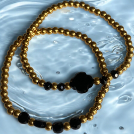Elastieke Armband van stainless steel kralen en 4 zwarte glas kralen.