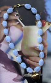 Lichtblauwe ketting in grove kraal met grote hart hanger van RVS (stainles steel). Goudkleurig.