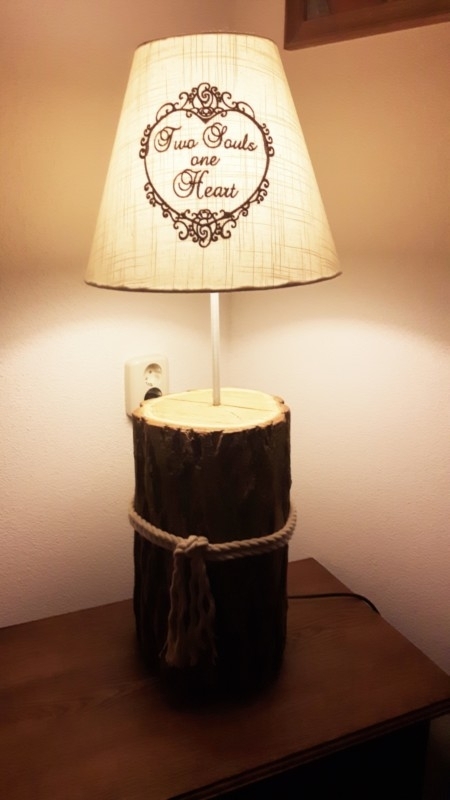 Lamp op een voet van een boomstam.