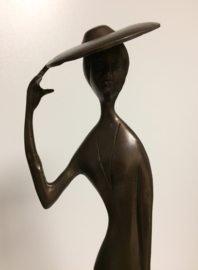 Vrouw met hoed op houten voet