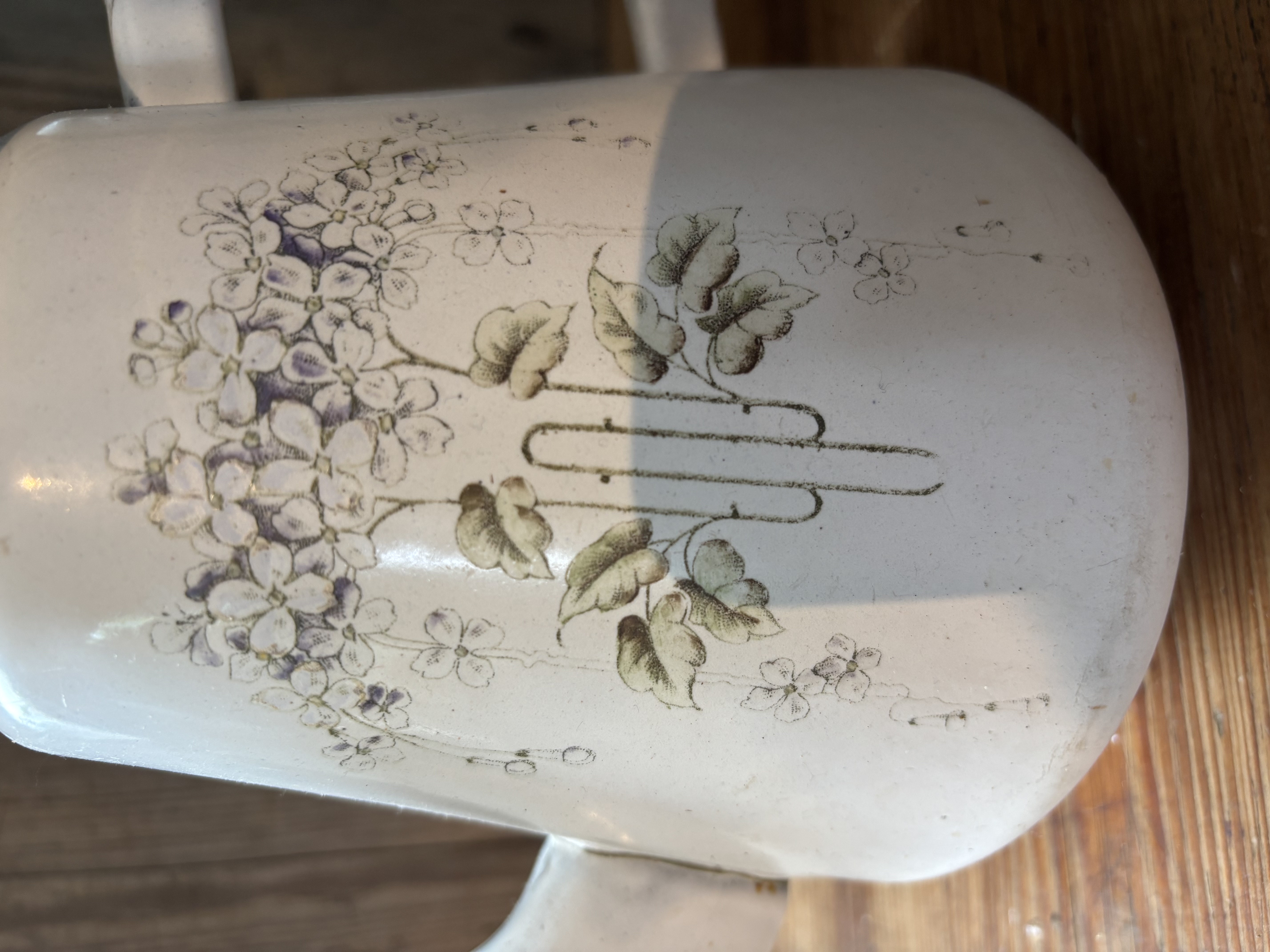 Oude witte kan met bloemen