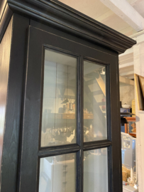 Smalle zwarte vitrinekast met onderkast.