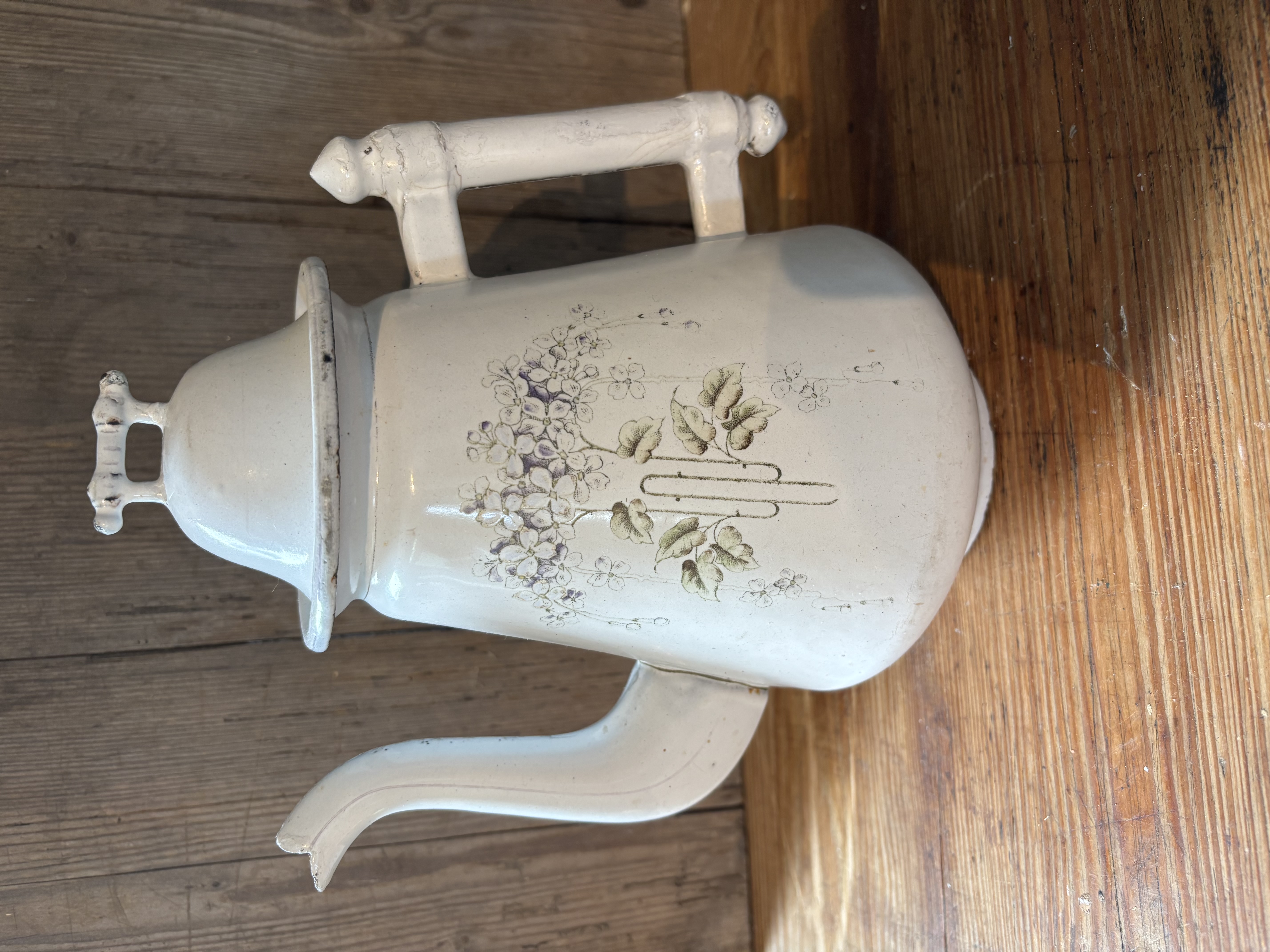 Oude witte kan met bloemen
