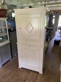 Zandkleurige brocante kast in twee delen.