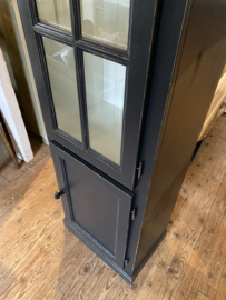 Smalle zwarte vitrinekast met onderkast.