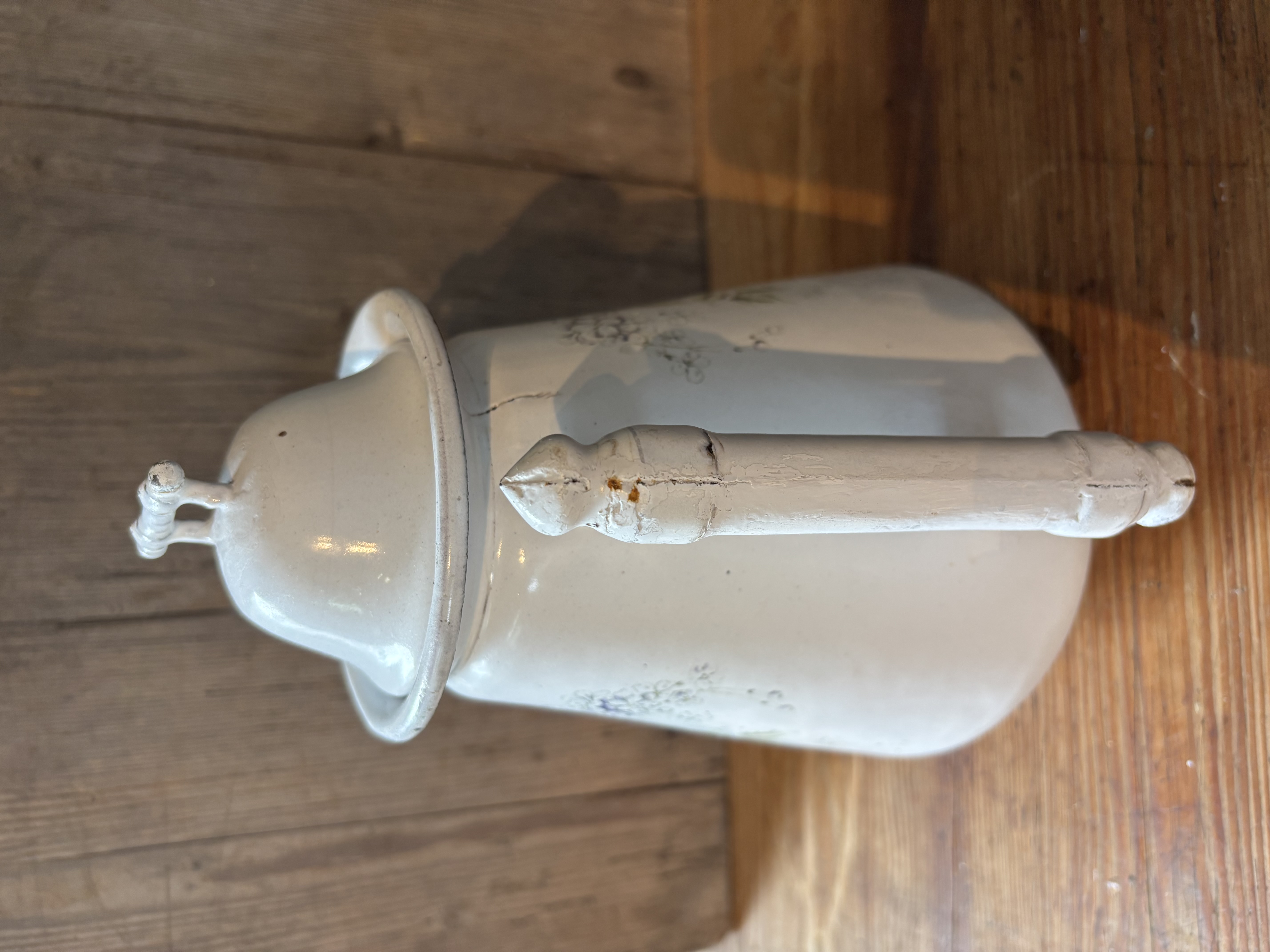 Oude witte kan met bloemen