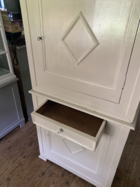 Zandkleurige brocante kast in twee delen.