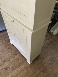 Zandkleurige brocante kast in twee delen.