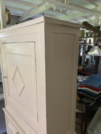 Zandkleurige brocante kast in twee delen.