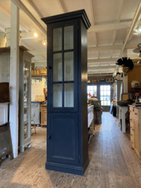 Smalle zwarte vitrinekast met onderkast.