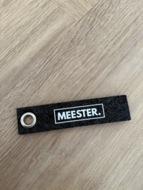 Donkergrijs MEESTER. Vilten Sleutelhanger Klas