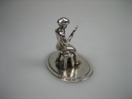 Zilveren miniatuur een dame zittend op haar krukje uit ca. 1981