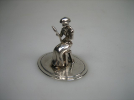 Zilveren miniatuur een dame zittend op haar krukje uit ca. 1980