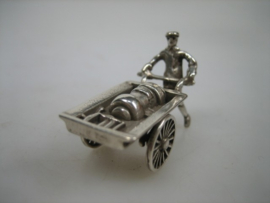 Zilveren miniatuur kachelsmid met handkar met draaiende wielen uit ca.1977