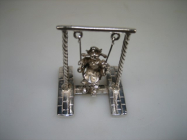 Zilver miniatuur met jong meisje op de schommel uit ca. 1958