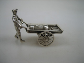 Zilveren miniatuur kachelsmid met handkar met draaiende wielen uit ca.1977