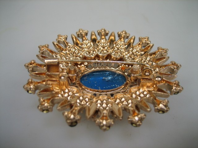 Broche met Blauwe synthetische steen rond gezet met heldere witte en blauwe glasstenen