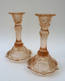 A pair of pink pressed glass candle holders