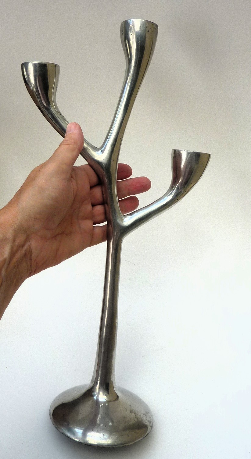 Een paar drie armige aluminium design kandelaars