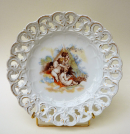 Antique reticulated porcelain plate with playing cherubs