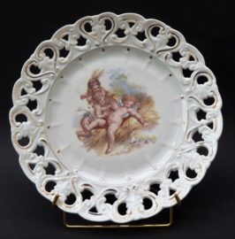 Antique reticulated porcelain plate with three cherubs in hay