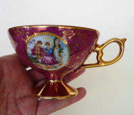 Gilded porcelain Fragonard Courting Couple cup with saucer