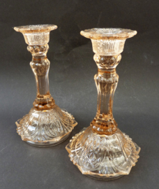 A pair of pink pressed glass candle holders