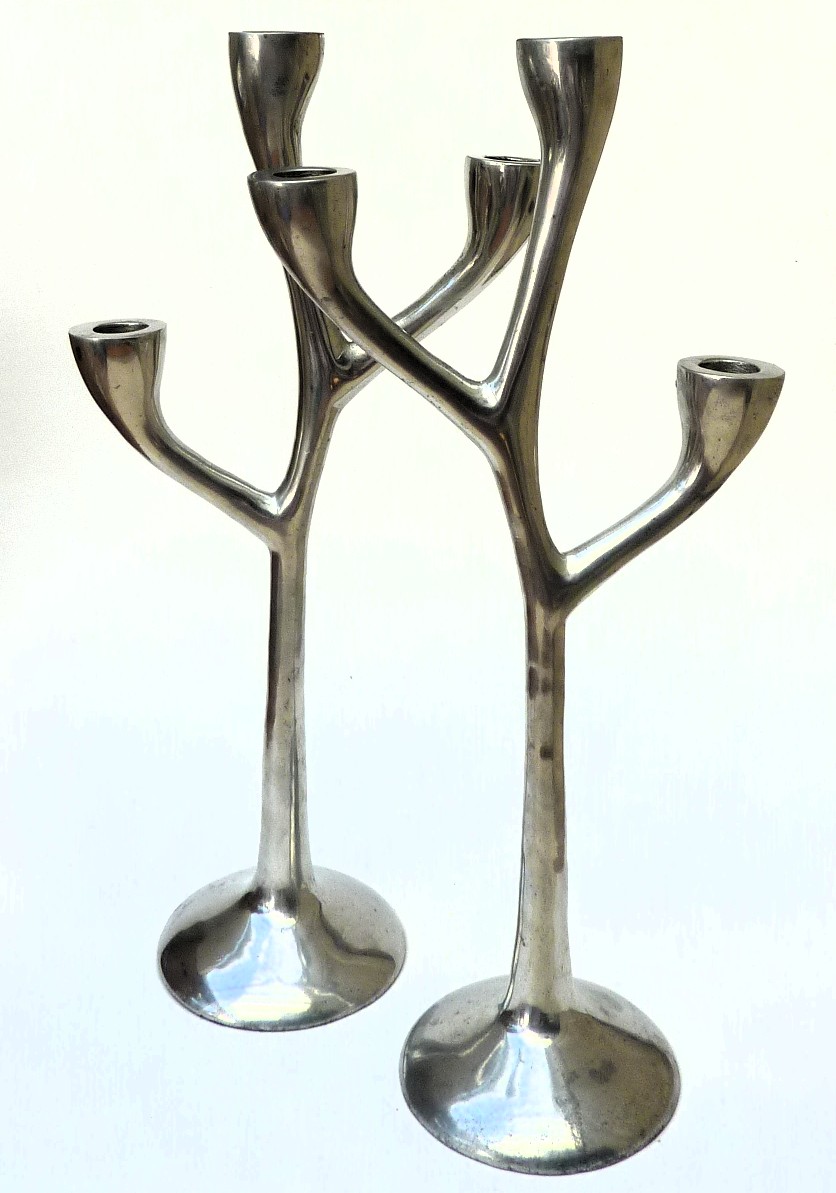 Een paar drie armige aluminium design kandelaars