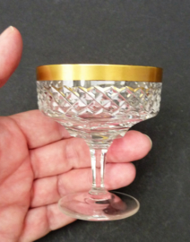 A pair of Hollywood Regency cut crystal liqueur coupe glasses with gold trim