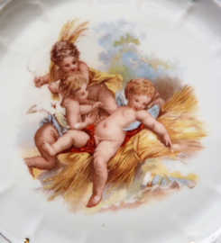 Antique reticulated porcelain plate with three cherubs in hay