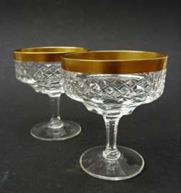 A pair of Hollywood Regency cut crystal liqueur coupe glasses with gold trim