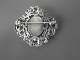 59; Broche met strik- en bloemmotieven.