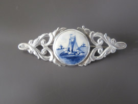 Elegant vormgegeven broche met ronde steen