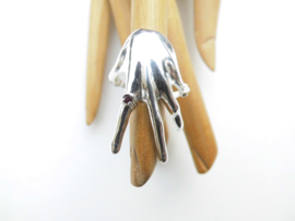 Zilveren hand ring met rood steentje.