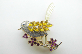 Broche gele vogel op rode bloemen.