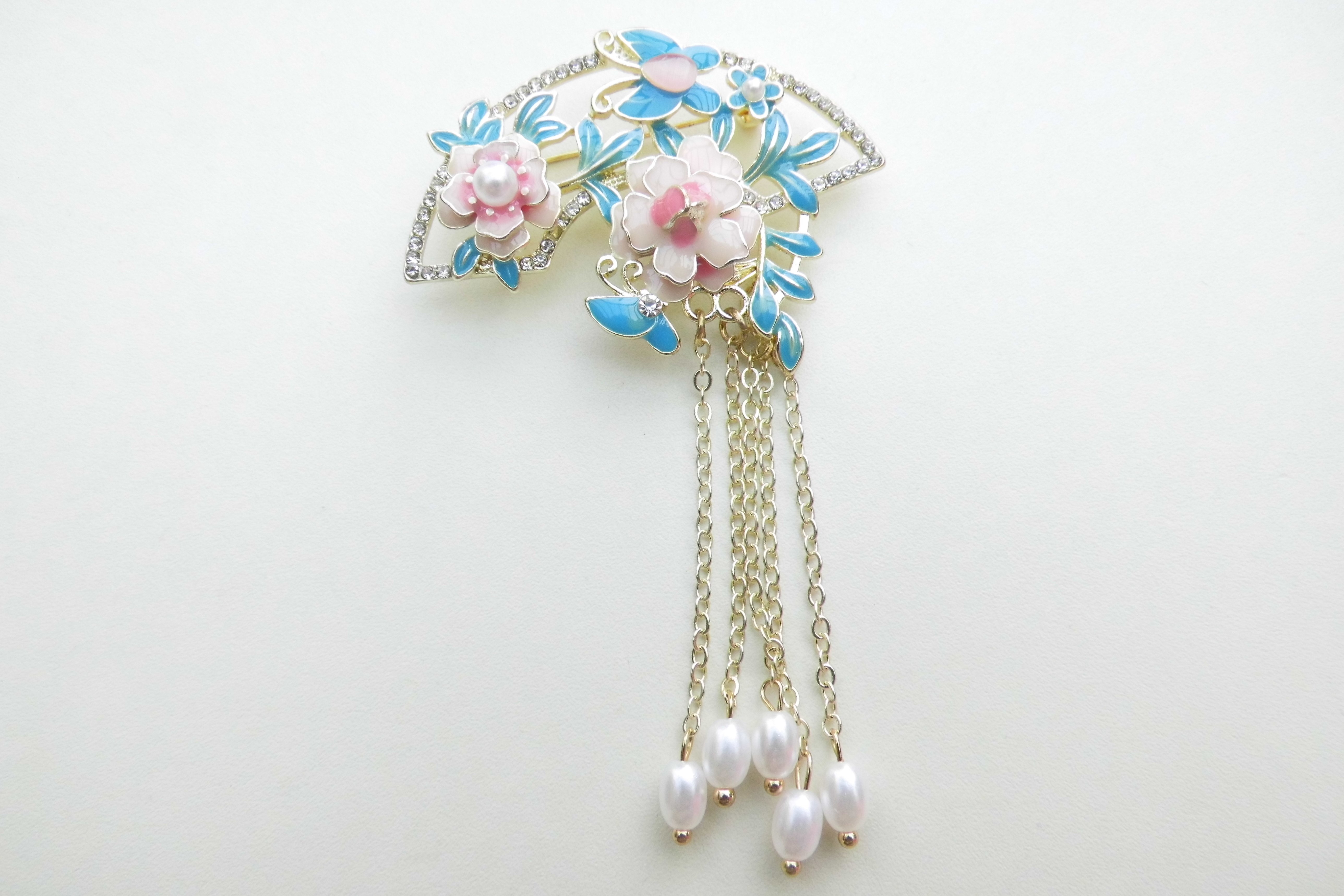 Broche roze bloem blauwe blaadjes synth. parels.