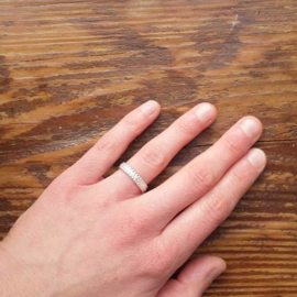 Zilveren ring met bewerkte band en parelranden