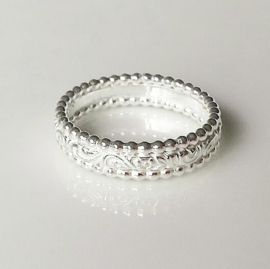 Zilveren ring met bewerkte band en parelranden
