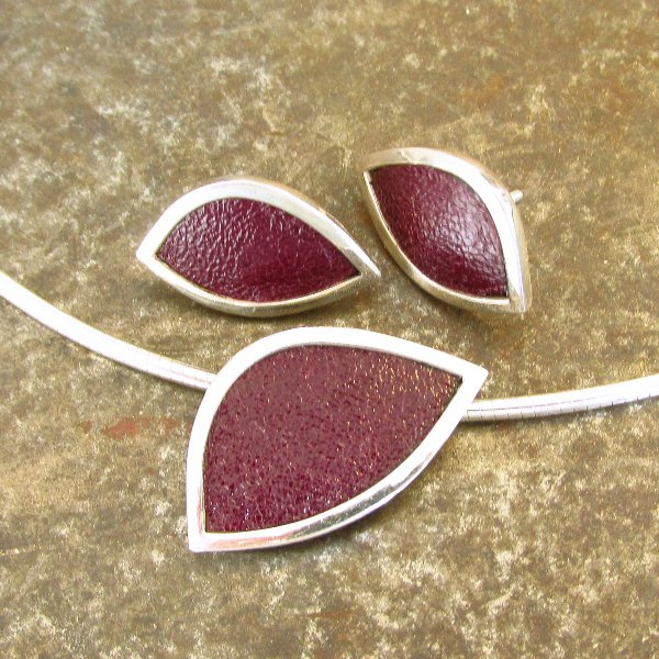 Set zilveren oorstekers en collier met hanger ingelegd met aubergine kleurig leer