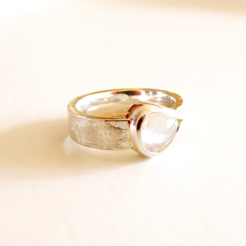 Zilveren ring met kantpatroon en wijde peervormige regenboogmaansteen